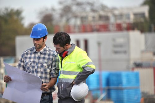 Two site workers sticking to the plans